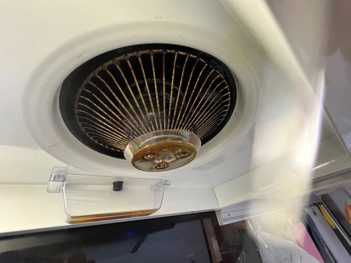 抽油煙機油杯與風扇護網清洗前累積的黃褐色油垢